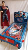Giant Superman doll standing next to the Superman pinball machine showing full view of both items.