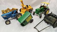 Overview of all six vintage metal farm equipment and tractor models arranged on white background.