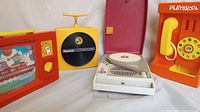 Panasonic 8-track player, Playskool plastic phone, Singer phonograph all visible from side view
