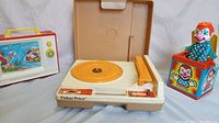 Photo showing Fisher-Price giant screen music box TV, vintage record player, and Jack-in-the-box clown toy.