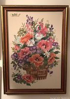 Overall view of the framed crewel embroidery showing the floral basket design in colors including orange, purple, pink, white, and green.