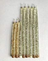 All nine Lucite candle-shaped decorative ornaments laid flat showing two color types and lengths.