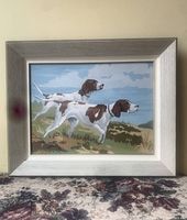 Frontal photo of the framed paint-by-number featuring two dogs in landscape