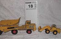 Wide view of both toy construction vehicles: No-K2 dump truck and No 69 tractor shovel, displaying size and condition