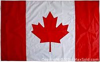 Photo of large commercial size Canadian flag showing red maple leaf centered on white panel with red vertical bands on each side, fabric slightly wrinkled and minor tattering on corner.