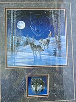 Close up of the print showing wolves in winter forest under full moon with wolf head in moon and smaller wolf head below.
