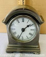 Front view of the pewter carriage clock showing white dial with Roman numerals and black hands.