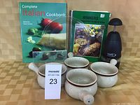 Photo showing four soup bowls, two cookbooks, power chopper, and glass pie plate partially visible between books.