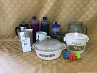 Group photo showing all items in lot including casserole dish, ice bucket, pottery jug, water bottles, travel mug, coffee mugs and colorful plastic objects.
