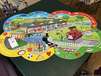Full view of the Thomas the Train floor puzzle spread out on a table showing the large, colorful pieces and detailed countryside scene.