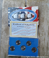 Full lot showing the Certificate of Authenticity above the clear hard plastic case holding five quarters in proof condition in a blue insert.