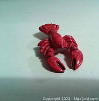 Red lobster-shaped bottle opener on plain white background