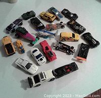 Top view showing entire lot of 22 toy cars and vehicles arranged on a white background