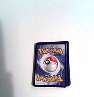 Photo of the backs of the Pokémon cards showing the classic blue Poké Ball design.