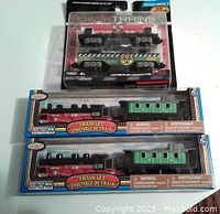 Three new in package Power Trains pieces including Search & Rescue and Emergency Response cars in Series 2 packaging along with two vintage-style red engine train sets with green carriages.