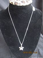 Full view of the necklace displayed on black velvet bust showing length and pendant size