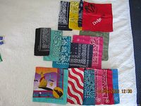 Overview photo showing all 16 cotton bandanas in various colors and patterns laid out spread across a white surface.