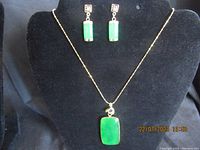 Full view of the necklace and earrings displayed on a black velvet bust to show the set's style and design.