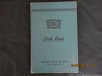 Cover of the cook book showing blue cover with emblem and title United Farm Women of Alberta, Fifth Edition