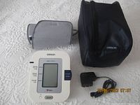 Complete set of blood pressure monitor device, cuff, carrying case, and power adapter.