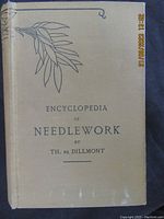 Front cover of the vintage book titled 'Encyclopedia of Needlework' by Th. De Dillmont showing botanical design.