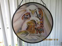 Photo of circular window sun catcher with painted First Nations eagle artwork, showing the full framed piece and hanging chain.