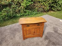 Front view of antique solid wood cabinet showing drawer and double doors.