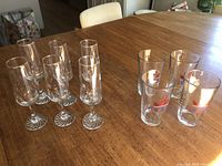 6 Olympic champagne flutes and 2 additional champagne flutes arranged on wooden table.