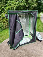 Front view of black and green Vivosun grow tent on lawn