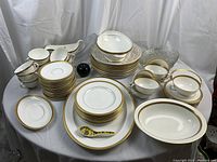 Wide overview of full set laid out on table showing plates, cups, bowls and serving pieces.