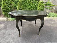Full front view of scalloped serpentine tabletop and cabriole legs