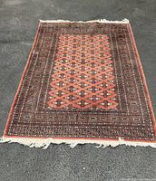 Full view of rug laid flat on asphalt surface