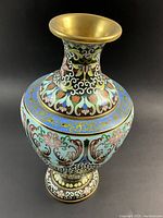 Full front view of vase showing flared rim, bulbous body and multicolor enamel motifs