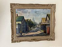 Full view of framed oil painting 'Provincetown Mass' showing street scene under cloudy sky