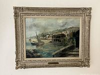 Full frontal view of framed oil painting showing coastal scene with sailboats and seaside town