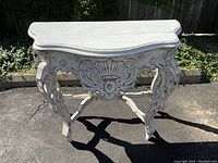 Full view of front and top showing serpentine front edge and carved apron