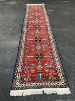 Full-length view of red Persian runner laid out on pavement