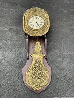 Full front view of entire wall clock on black surface