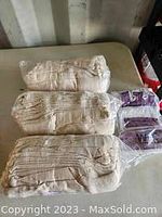 Photo showing three pairs of tan-colored gardening gloves sealed in plastic packaging.