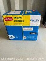 Box of 12 reams of Staples printer paper, showing front and top packaging details.