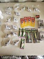Top view of various fishing components in sealed plastic bags and packaged lures