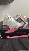 Full view of the new kids shoes size 11 in shiny silver with blush pink lining on branded box