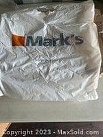 Photo of large white plastic bag packaging with Marks logo printed