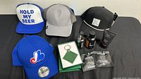 Four men's caps, Lacoste keychain in box, and various men's grooming products on a table