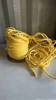 Spool of yellow twisted rope, partially unwound and arranged on surface.