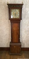 Full view of oak longcase clock showing entire height, case design and finials