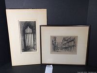 Two framed etchings: one vertical gothic cathedral window etching, one horizontal street scene etching.