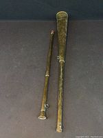 Two-piece brass horn lying horizontally, showing overall length and split parts.