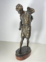 Front view of bronze statue showing figure and marble base