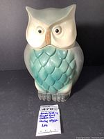 Front view of owl-shaped brush pottery cookie jar with visible seller note.